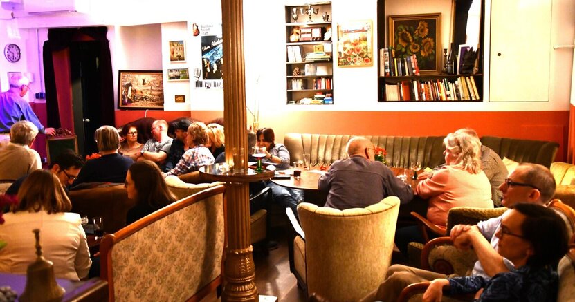 Das Theatercafé der BüchnerBühne. Zu sehen sind Menschen, die im Theatercafé der BüchnerBühne sitzen.