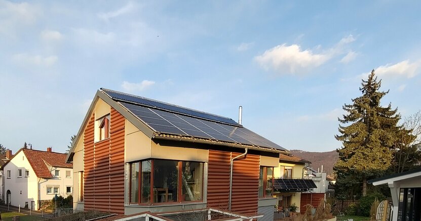 Zu sehen ist ein Haus mit Solarkollektoren und PV-Modulen