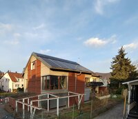 Zu sehen ist ein Haus mit einer Photovoltaik-Anlage auf dem Dach