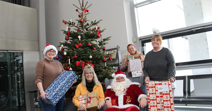 Das Wunschbaumteam Sandra Vetter, Yvonne Dickler, der Weihnachtsmann, Rebecca Klos und Tanja Demuth (v.li.) vor dem Wunschbaum im Rathausfoyer.