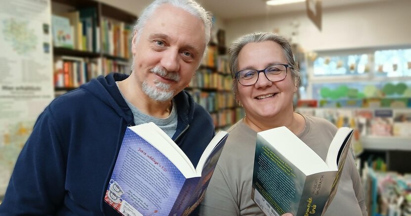 Oliver Bopp und Claudia Borek von der Buchhandlung Faktotum freuen sich auf den Start des Silent Book Club Ried Oliver Bopp und Claudia Borek von der Buchhandlung Faktotum stehen in ihrer Buchhandlung. Sie halten jeweils ein aufgeschlagenes Buch in der Hand und lächeln in die Kamera.