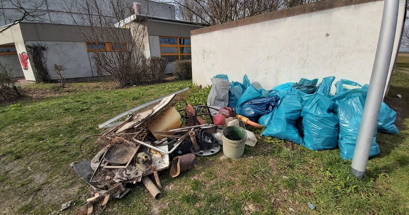 Auch bei der alljährlichen Riedstädter Müllsammelaktion im Frühjahr wird stets erschreckend viel Unrat am Erfelder Altrheinufer eingesammelt. Viele prall gefüllte blaue Müllsäcke sowie verschmutzte Metallteile, zerbrochene Keramik und vieles mehr liegen auf einer Wiese vor einer Mauer. Sie wurden bei einer früheren Müllsammelaktion am Erfelder Altrheinufer gefunden.