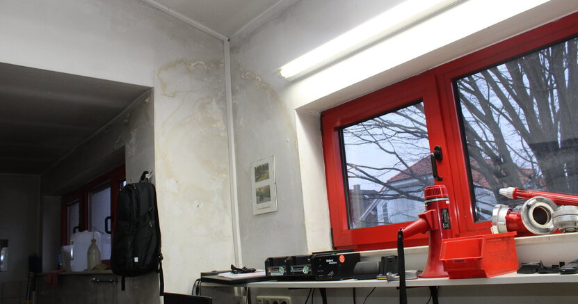 Bei einer Begehung im März 2025 hatten sich die Mitglieder des Bauausschusses vom schlechten Zustand der Feuerwehrhäuser Goddelau und Erfelden überzeugt. Hier zu sehen ein Wasserschaden im Feuerwehrhaus Erfelden. In einem Raum des Feuerwehrhauses Erfelden ist ein großer Wasserschaden zu sehen: In einer Ecke der Zimmerdecke und zwei Wände herunter ziehen sich dunkle Flecken.