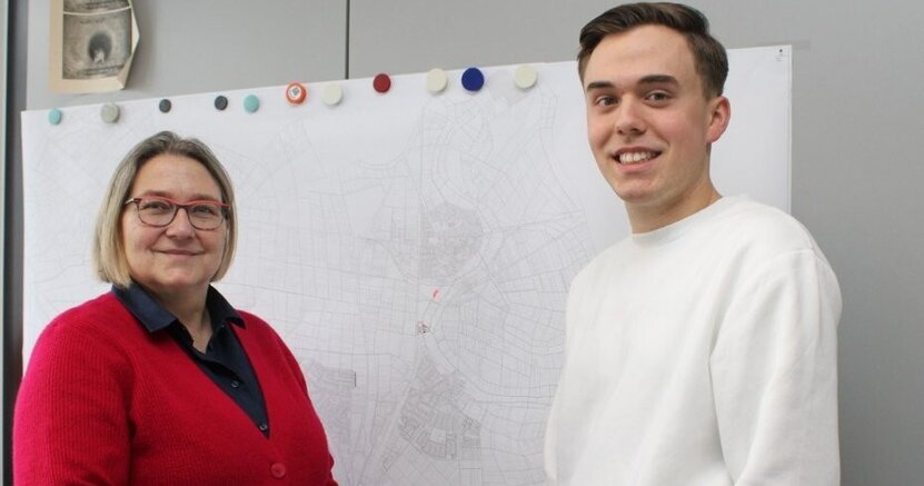 Stadtwerkeleiterin Saskia Kirsch und Dualer Student Florian Schmidt. Stadtwerkeleiterin Saskia Kirsch und Dualer Student Florian Schmidt stehen vor einer Karte.