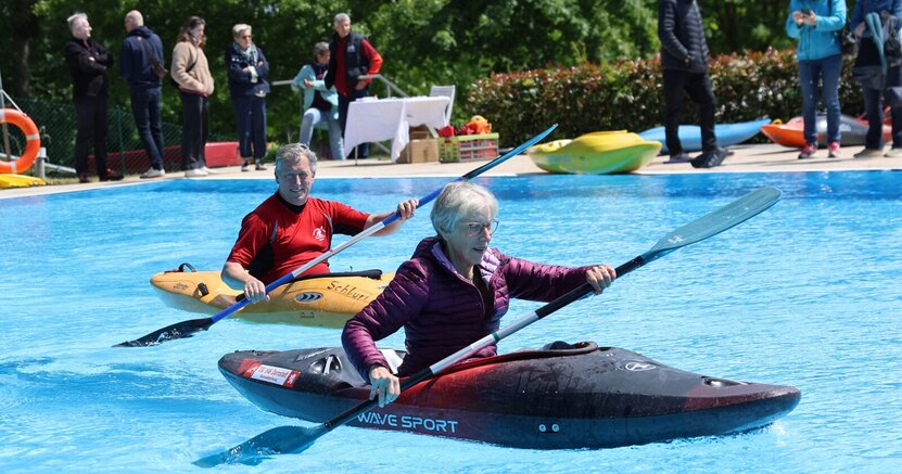 Auch Schnupperpaddeln gehörte zum Angebot. Eine Frau und ein Mann sitzen jeweils in einem Kajak und paddeln im Schwimmerbecken.