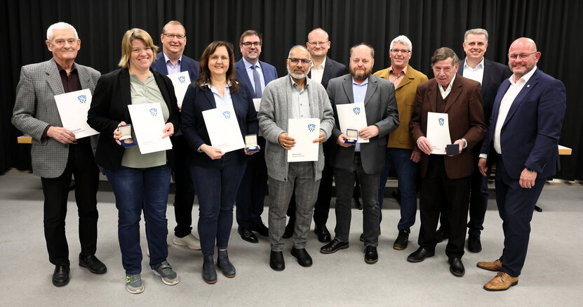Gruppenbild mit Ehrenplaketten: Dieter Frey, Katja Kamenik, Matthias Lachmann, Melanie Dörr, Guido Funk, Ahmad Muzaffar Mahmood, Michael Fraikin, Matthias Thurn, Ottmar Eberling, Frank Fischer, Heiko Büßer und Bürgermeister Marcus Kretschmann (v.li.) Auf der Bühne der Heinrich-Bonn-Halle stehen die Ausgezeichneten mit Ehrenplaketten und Urkunden. Von links nach rechts:Dieter Frey, Katja Kamenik, Matthias Lachmann, Melanie Dörr, Guido Funk, Ahmad Muzaffar Mahmood, Michael Fraikin, Matthias Thurn, Ottmar Eberling, Frank Fischer, Heiko Büßer und Bürgermeister Marcus Kretschmann