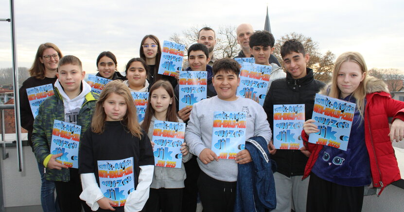Die Deutsch-Intensivklasse präsentiert ihren Foto-Comic. Mit dabei Lehrerin Melanie Sinner (li), Fachbereichsleiter Rick Hölzer und Jugendpfleger Heiko Wambold (hinten, v.li.)