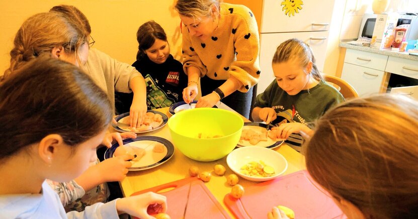 Im letzten WinterFun wurde an einem Tag mit Jugendpflegerin Julia Spitzer gekocht. Dieses Mal gibt es mit ihr einen Kunstworkshop. Zu sehen ist ein Bild vom letzten WinterFun. Darauf kocht Jugendpflegerin Julia Spitzer mit Kindern.