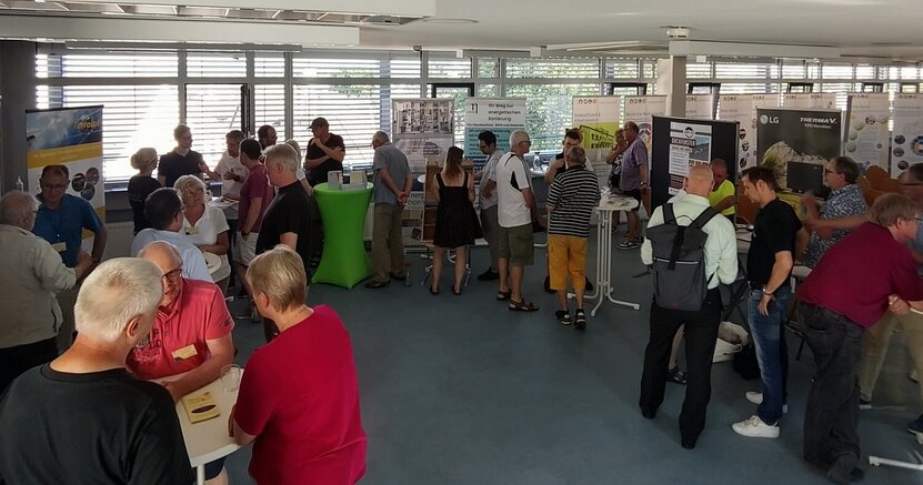 Hohes Interesse und reger Austausch: Die Hausmesse und das Werkstattge-spräch zur kommunalen Wärmeplanung im Rathaus Goddelau waren ein voller Erfolg. Im Sitzungssaal des Riedstädter Rathauses stehen viele Menschen an Infoständen und an Stehtischen und unterhalten sich.
